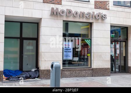 Obdachlose schlafen in der Tür von geschlossen wegen Covid-19 Pandemie McDonald`s Restaurant in der Henry Street in Dublin, Irland Stockfoto